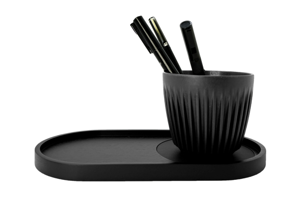 CURATED BUSINESS GIFT SET: CIRCLES + PLEATS + features a black charcoal cup made from coffee husk, ideal as a pen holder, shown holding pens.