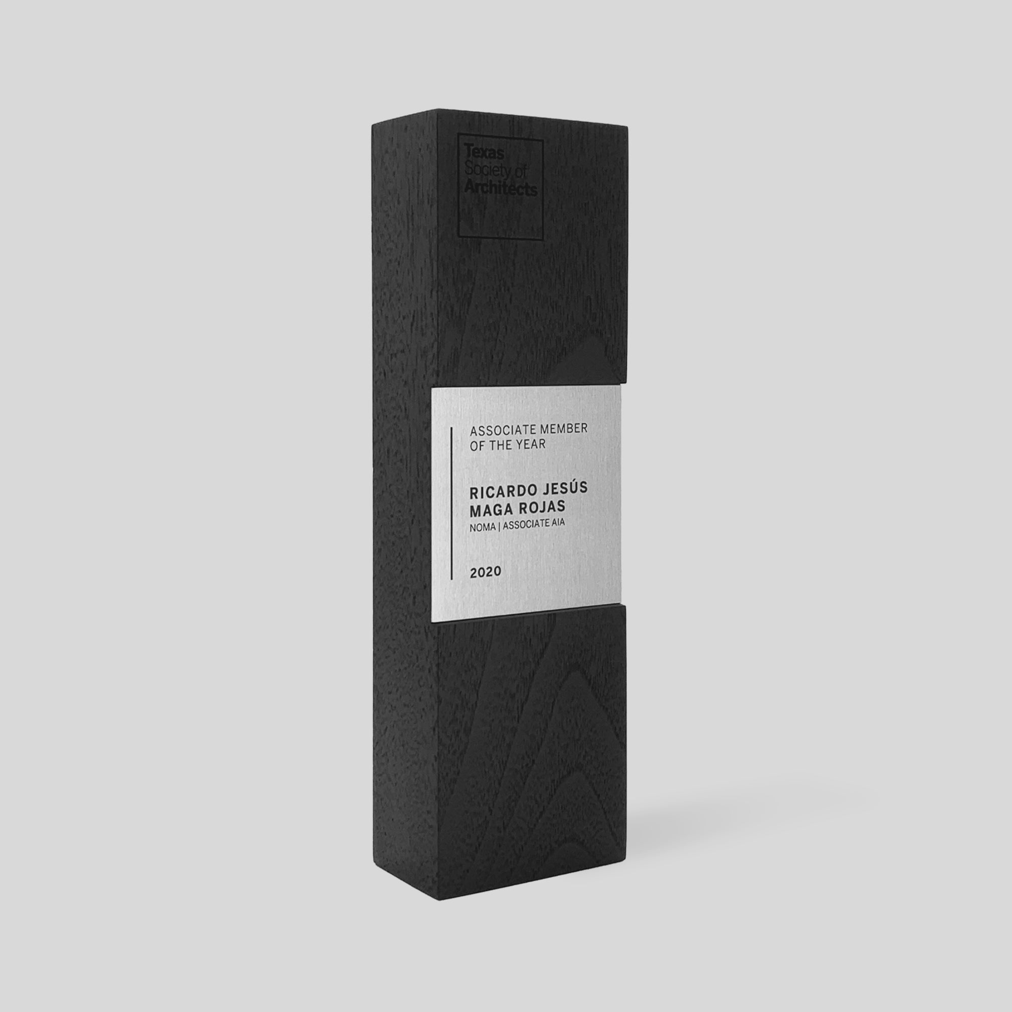 Figura Quadrum Award, a black rectangular box with a white label, featuring a refined square nameplate, symbolizes stability and strength in a sophisticated design.