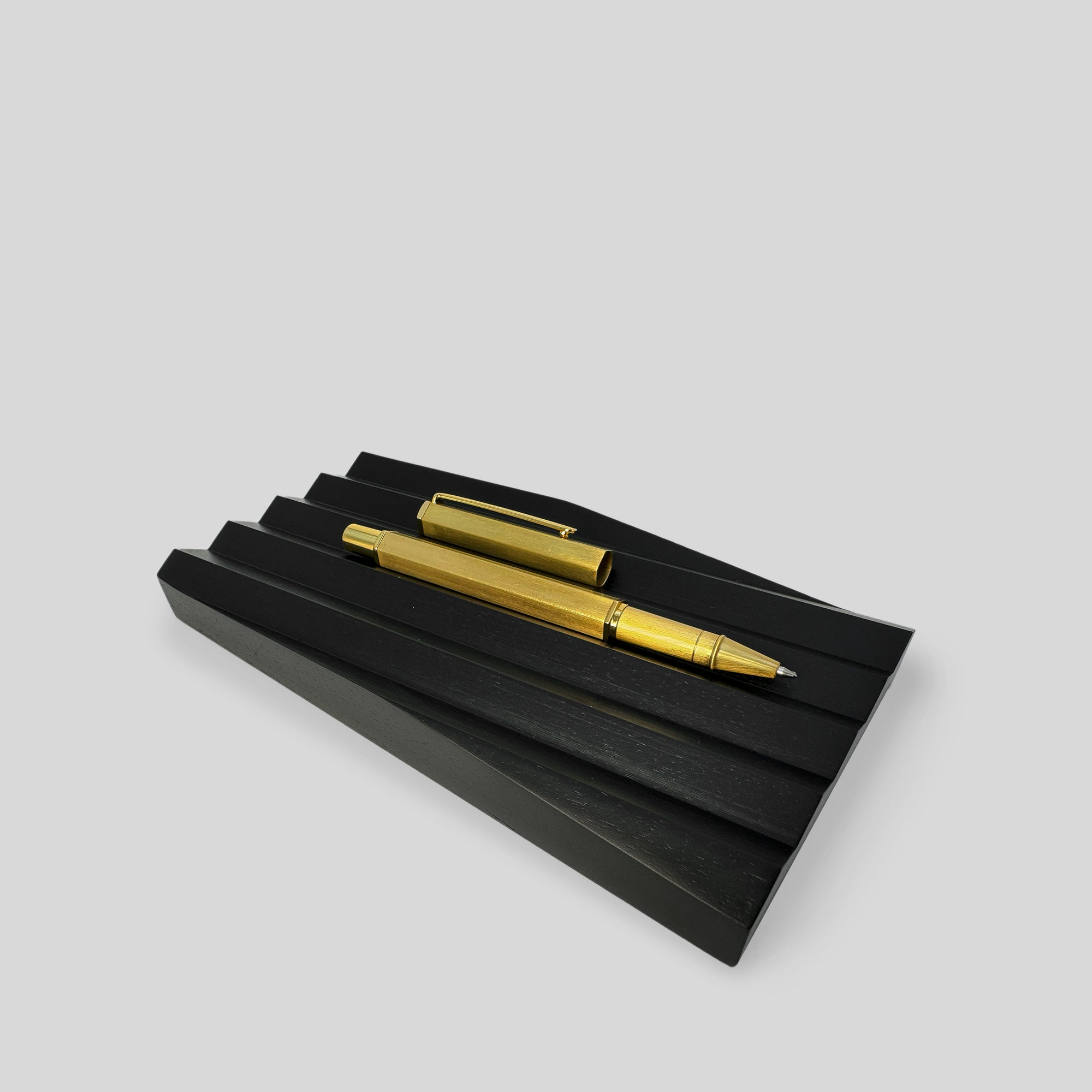 Business Gift: Thinking by Hand featuring a sleek black and gold pen resting on a sophisticated black stand, perfect for elegant writing and gifting.