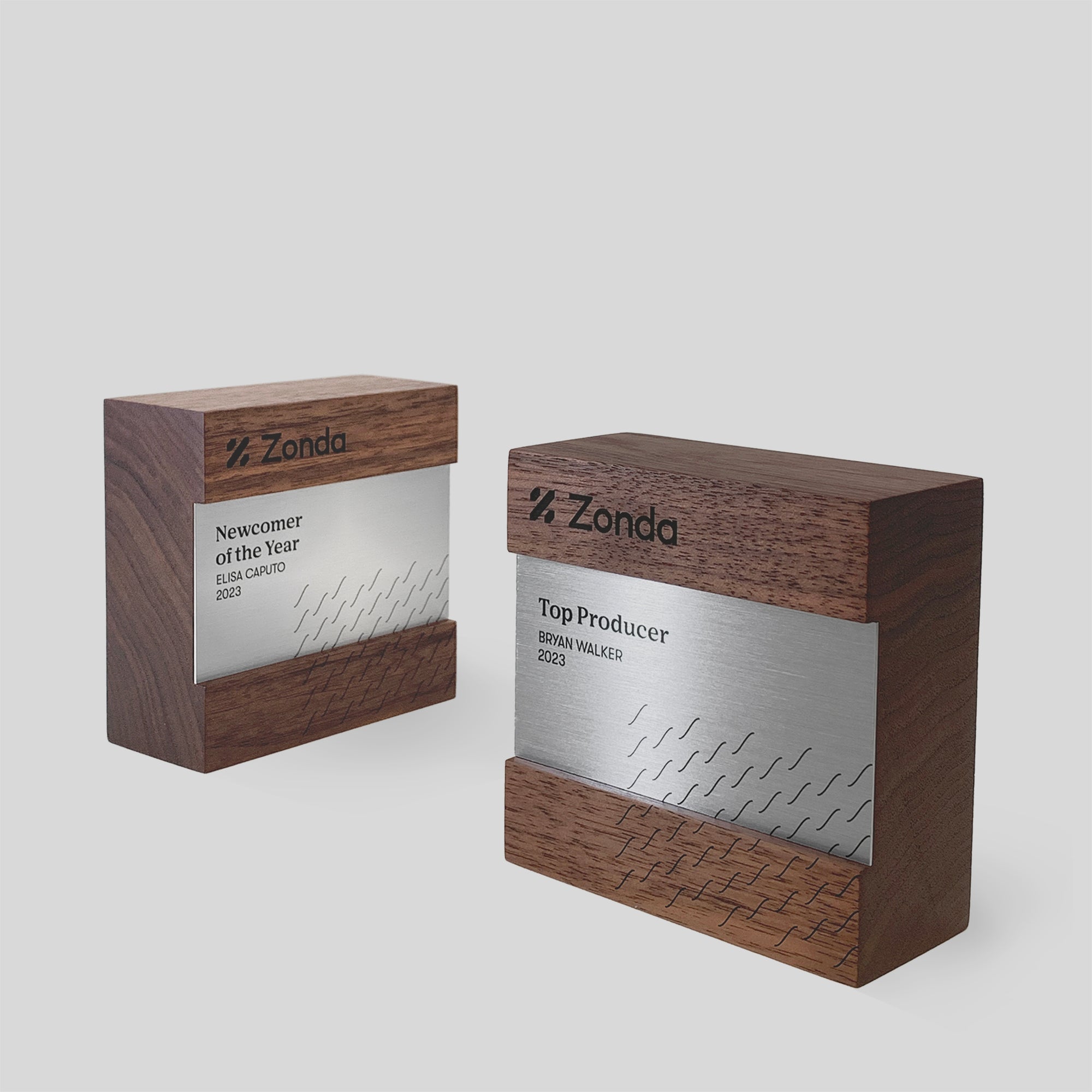 Figura Quadratum Award featuring two wooden boxes with silver and black text, showcasing a minimalist design with polished metal accents, ideal for recognition.