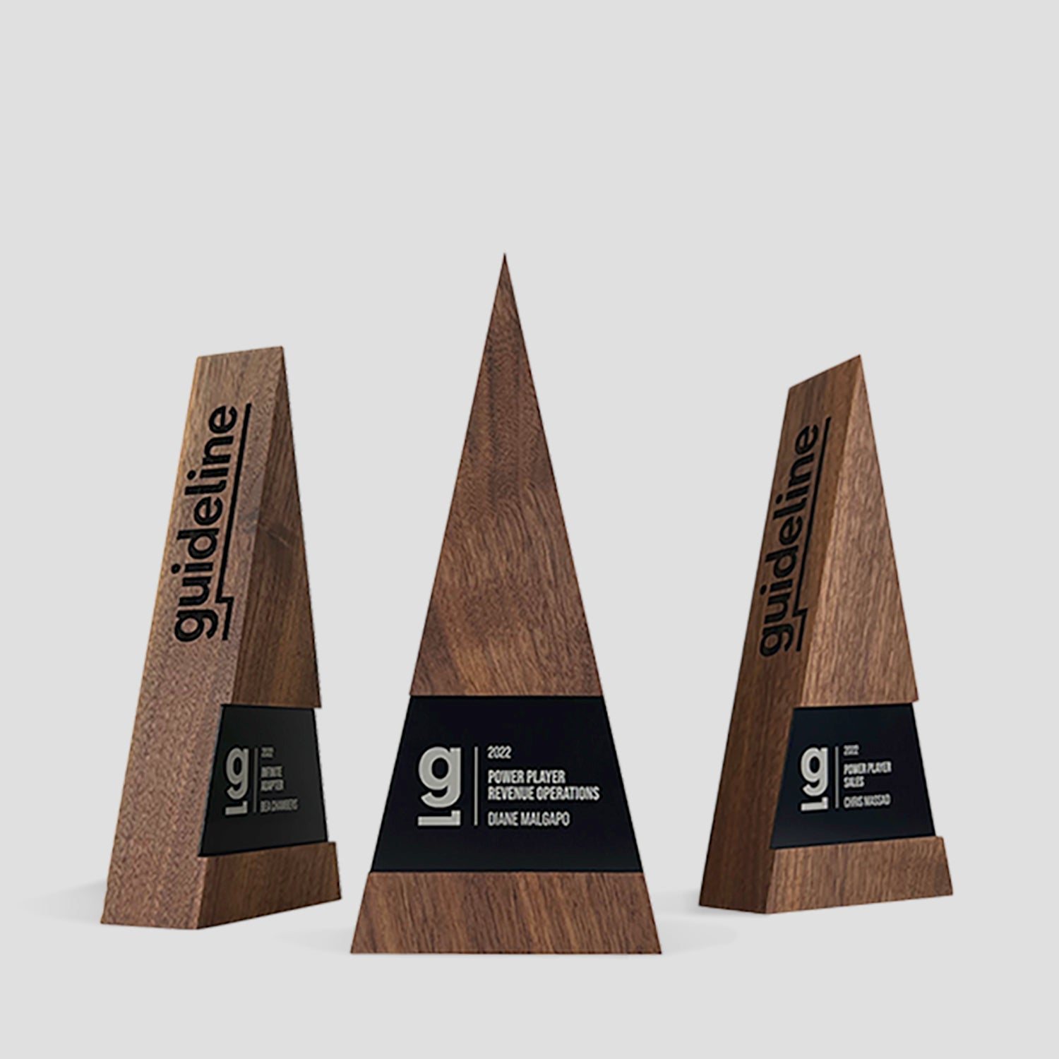 Figura Trigonum Award: A wooden trophy with a triangular design, integrating walnut, maple, and metal elements, symbolizing growth and excellence, expertly engraved for personalization.