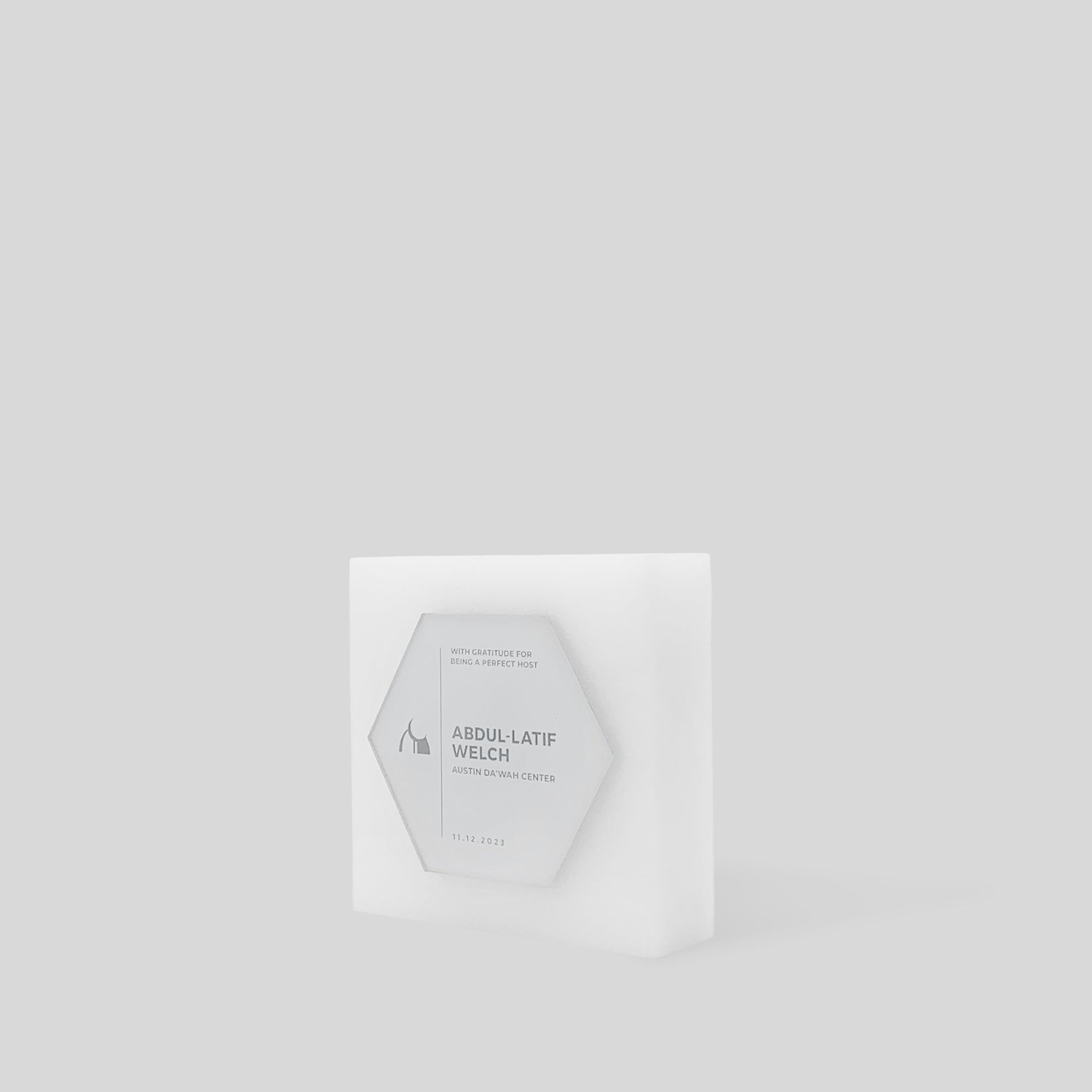 Glacio Award Hexagon: A geometric, modern acrylic award with a hexagonal design, featuring a frosted, layered structure on a square base, symbolizing excellence and teamwork.