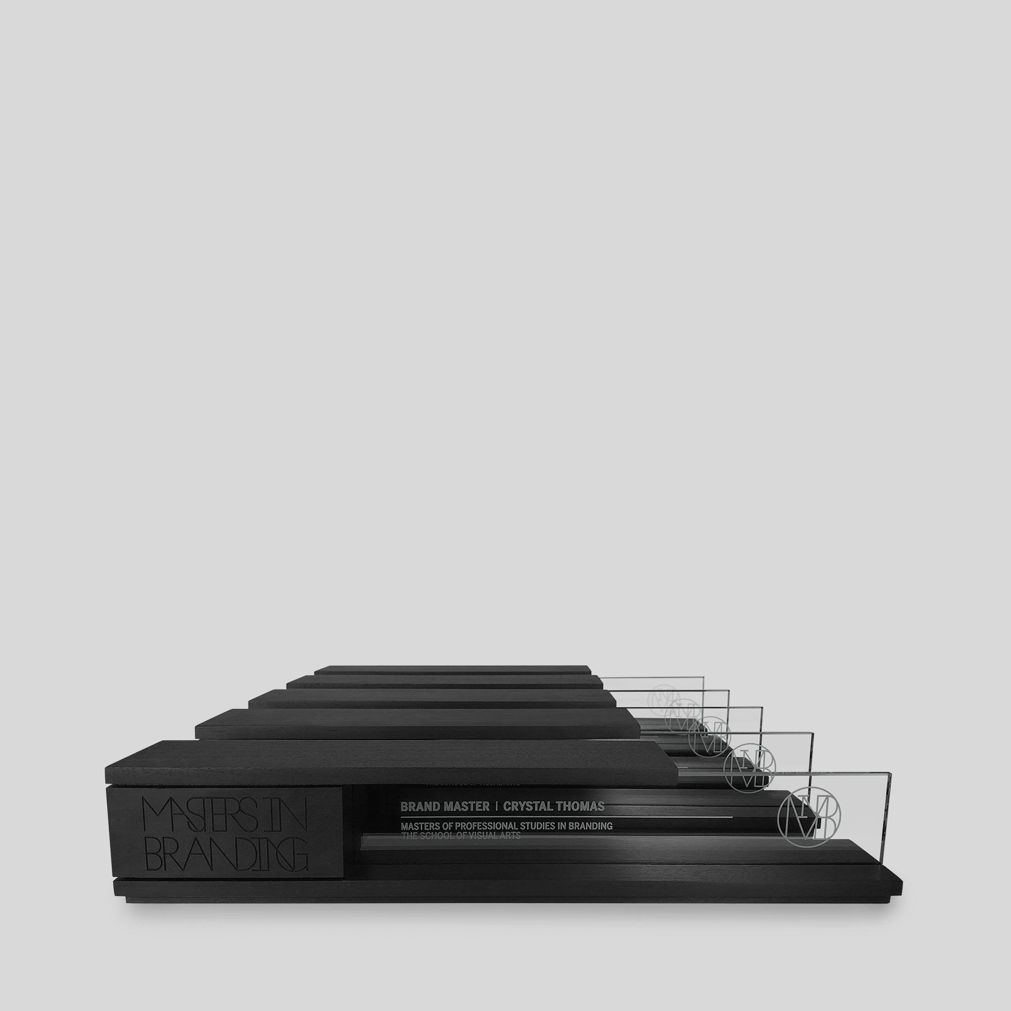 Portico Award, a black rectangular object symbolizing balance and achievement, features a cantilevered top and nameplate, part of Trophyology&#39;s Inceptum Collection.