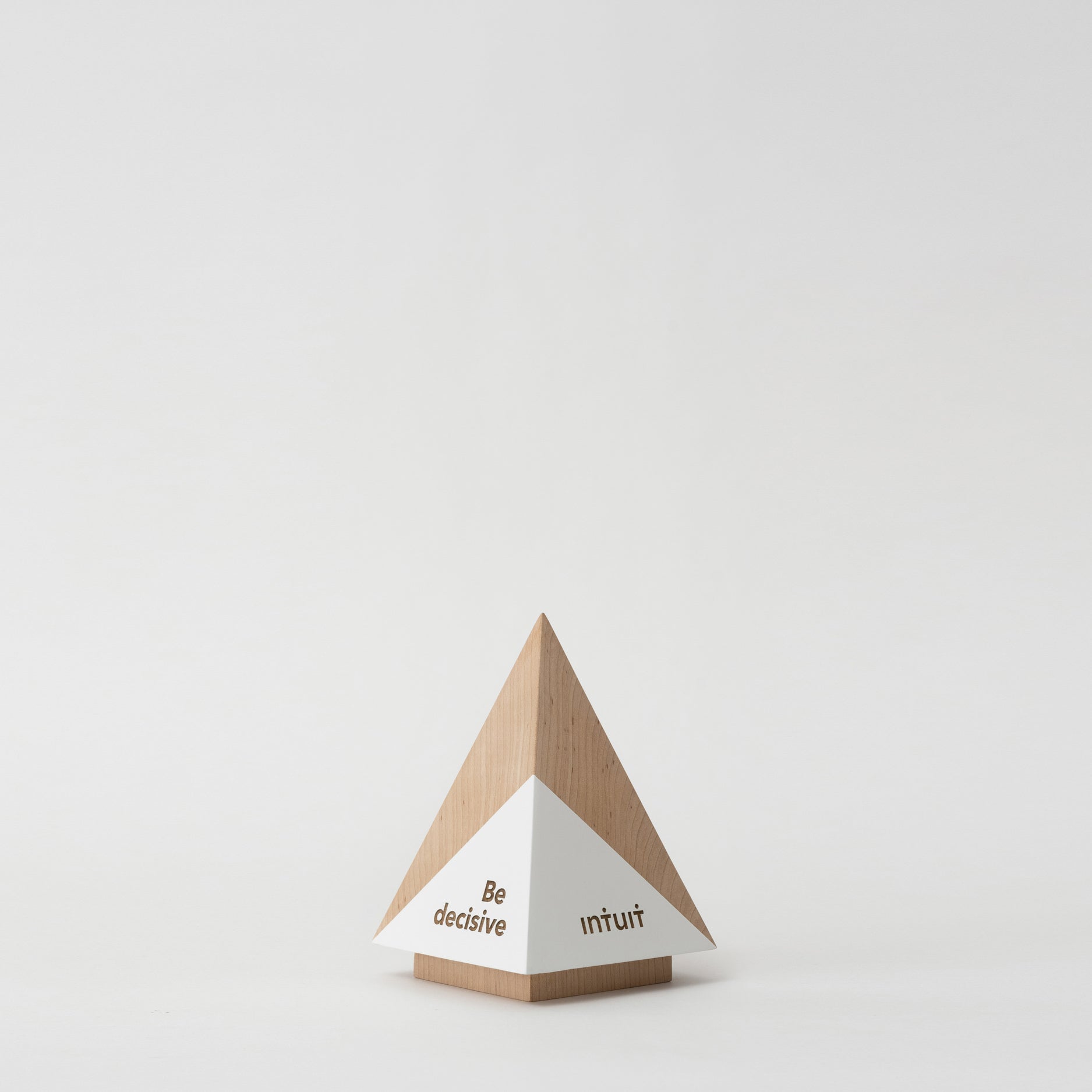 Geometria Award Pyramis, a wooden pyramid with a white triangle, symbolizes achievement, crafted from solid walnut or maple, ideal for personalized engraving.